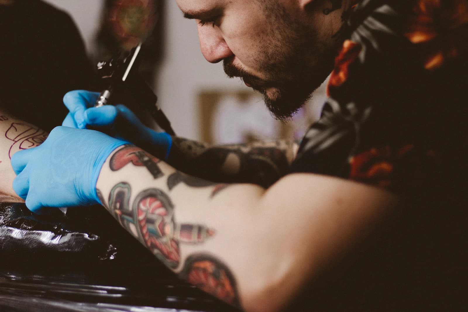 Tattoo artist working carefully with a client